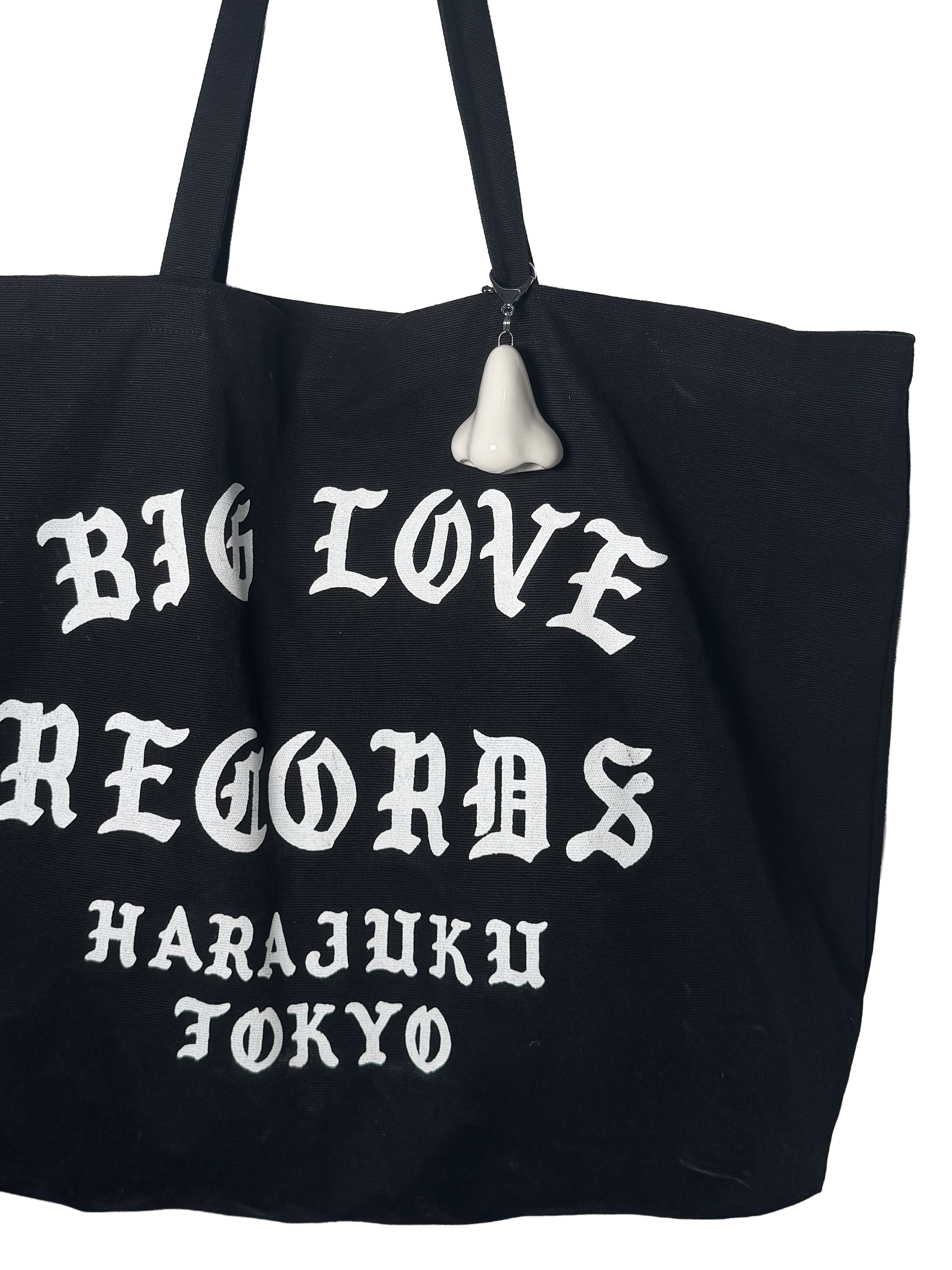 Black tote bag with 'BIG LOVE RECORDS HARAJUKU TOKYO' text and a white nose keychain on a white background